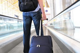 homem em aeroporto levando malas