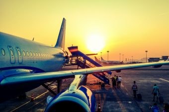 Passagens aéreas mais baratas: imagem de um avião na pista durante o por do sol