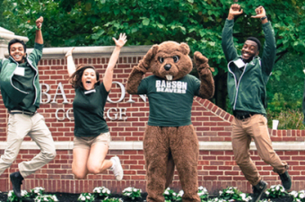 estudantes de graduação em Babson College saltam em frente aos portões da universidade