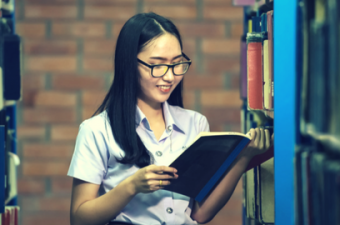 mulher oriental estudando em biblioteca