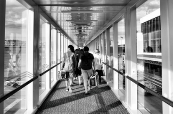 Pessoas de costas caminhando para o embarque em um aeroporto