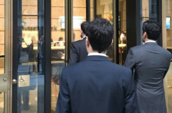 Profissionais de terno entrando em Deutsche Bank em Wall Street