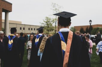 Pessoa com traje de formatura virada de costas