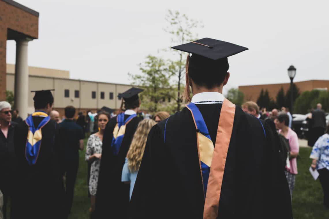 Pessoa com traje de formatura virada de costas