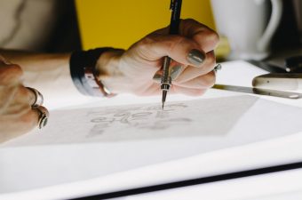 Pessoa desenhando em mesa iluminada, prêmio de design de produto