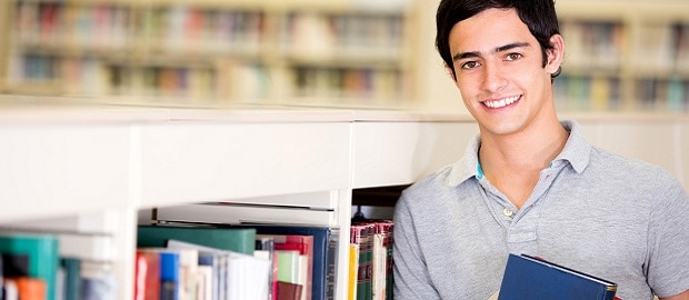 jovem segurando livro com biblioteca ao fundo