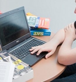 jovens estudando com computador e livros SAT