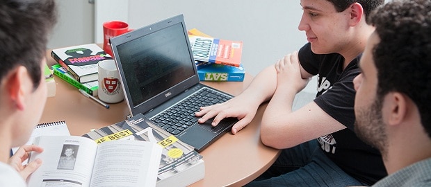 jovens estudando com computador e livros SAT