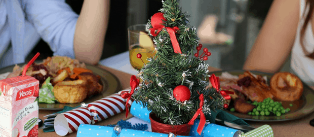 pessoas em volta de uma mesa com enfeites de Natal