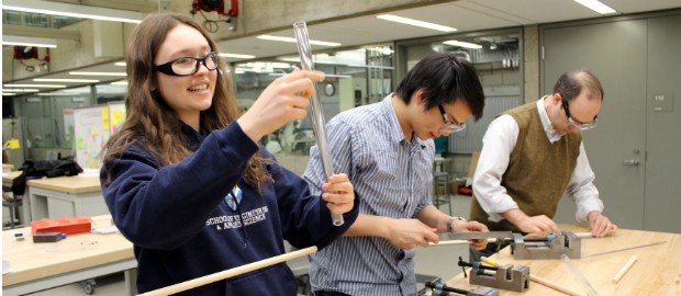 aluna em laboratório junto a professores