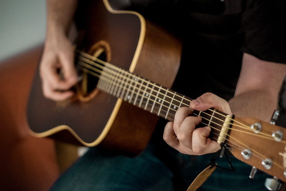 Pessoa tocando violão - atividades extracurriculares no ensino médio