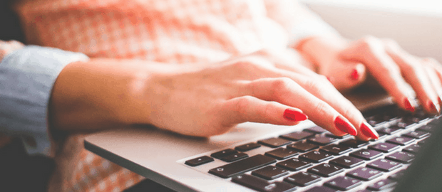 mãos de mulher com unhas pintadas usando o notebook