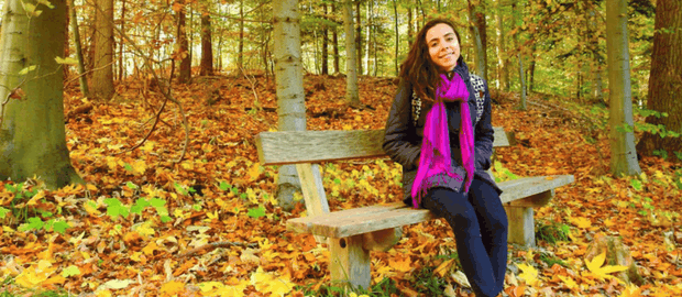Jovem sentada em um bosque no outono