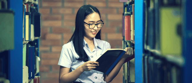 mulher oriental estudando em biblioteca