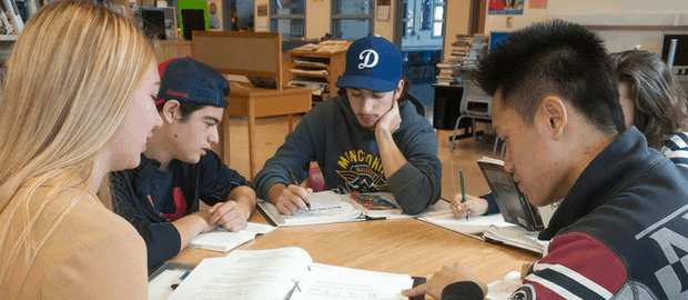 jovens estudando ao redor de uma mesa