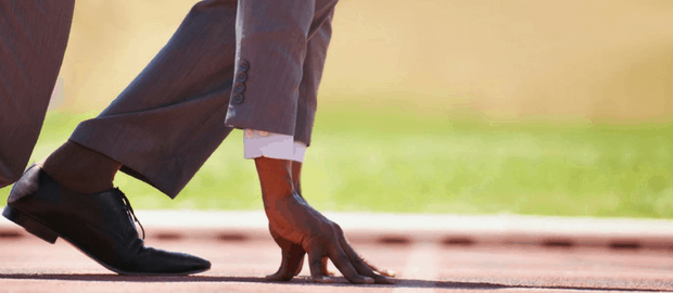 homem de terno em posição de preparação para corrida