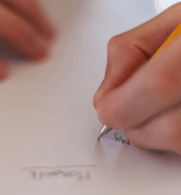 Mão esquerda escrevendo uma redação