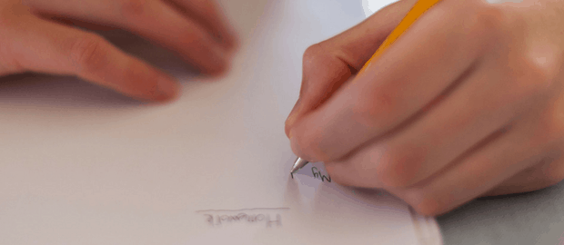 Mão esquerda escrevendo uma redação