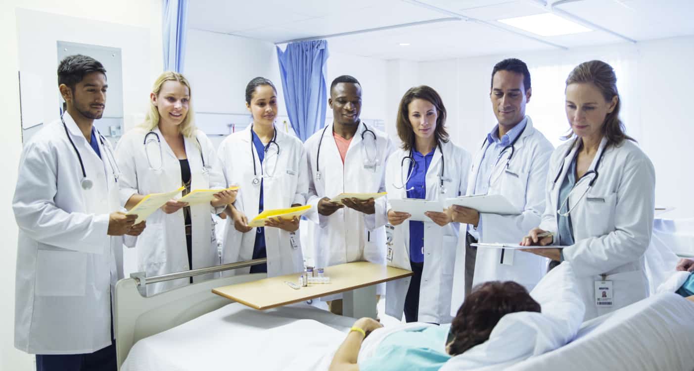 Doctor and residents examining patient in hospital room