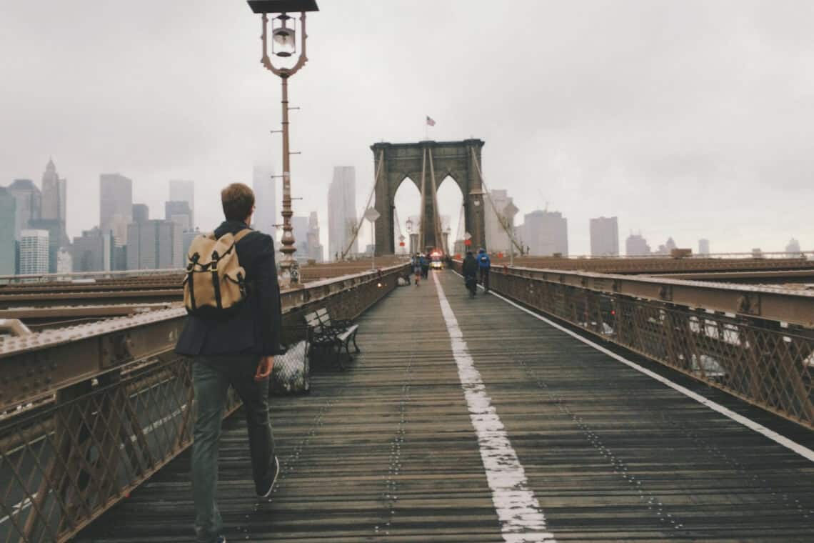 jovem caminhando na brooklin bridge