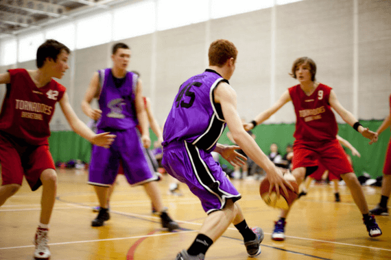 atletas universitários jogando basquete