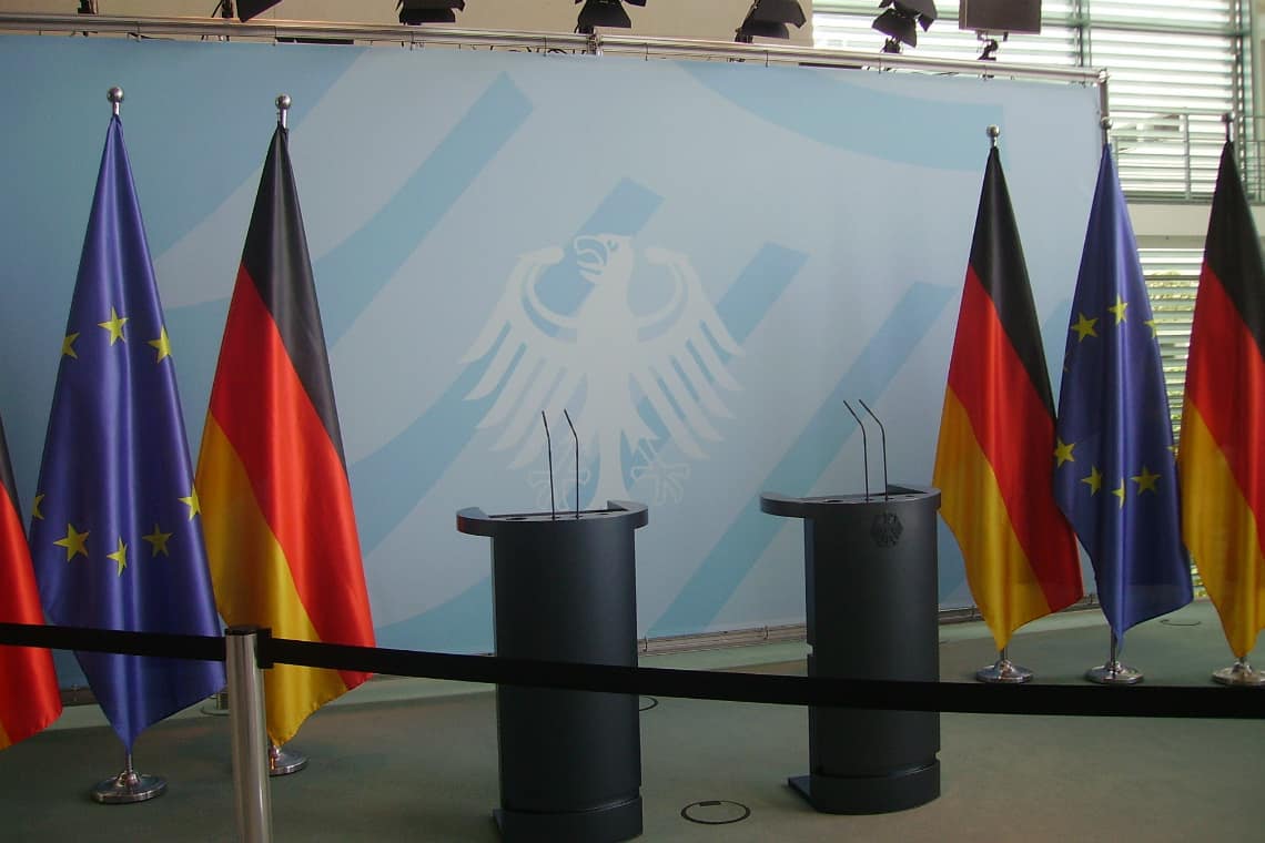 Bandeiras da Alemanha e da União Europeia atrás de dois palanques