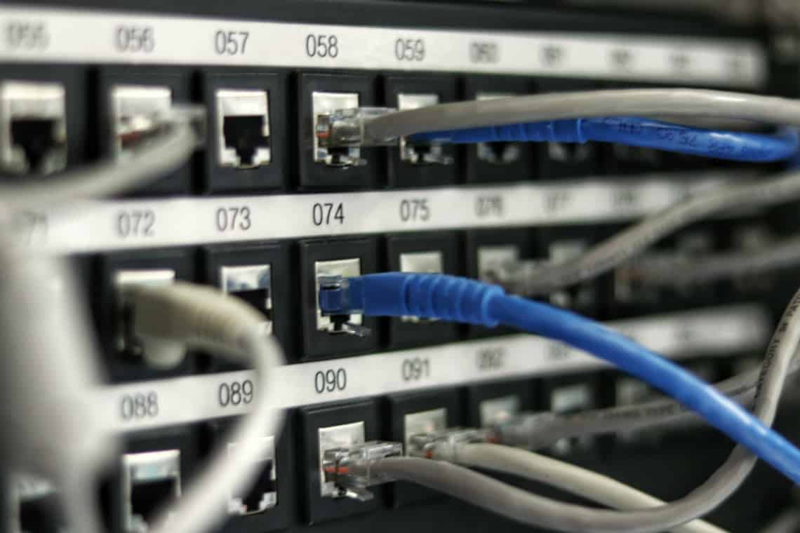 Um entroncamento de rede, com diversos cabos de rede saindo dele / bolsas de estudo em Segurança da Informação