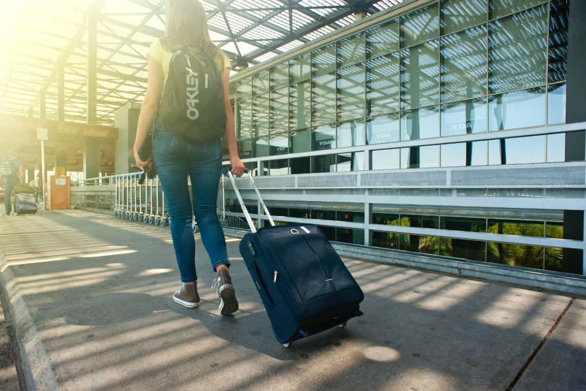 Moça com mala e mochila - graduação no exterior- dicas para estudar fora