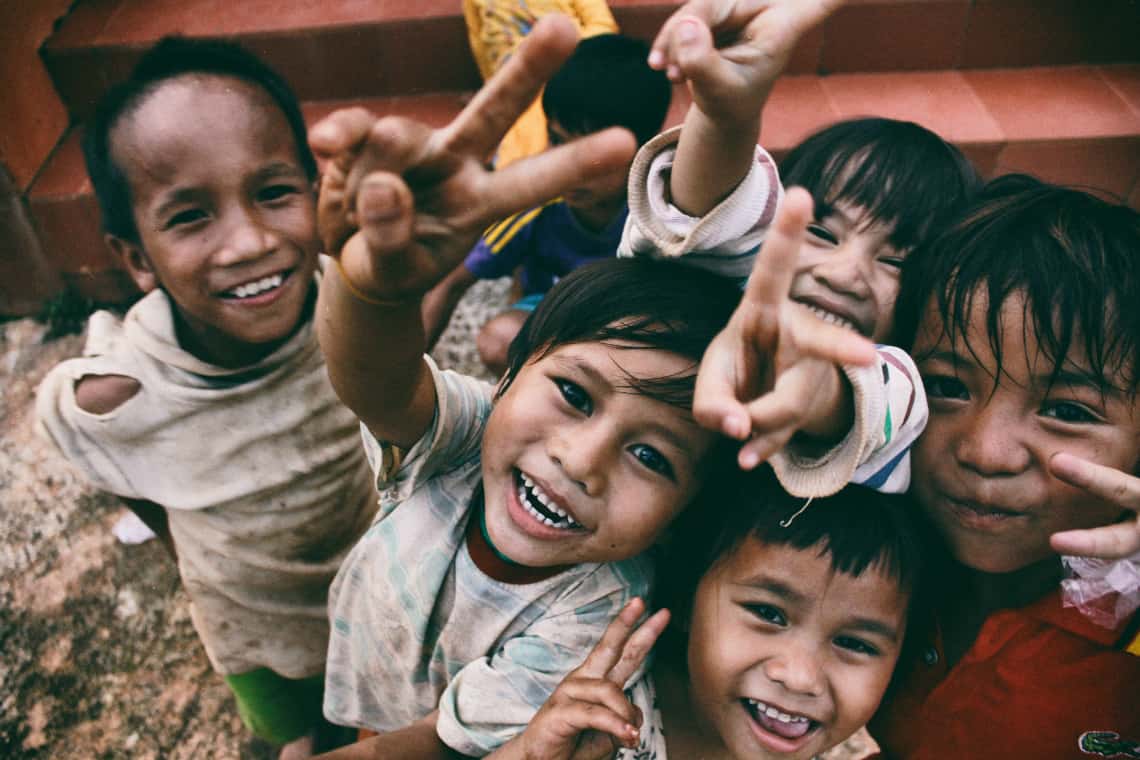 Cinco crianças sorrindo para a câmera e fazendo o sinal da paz / mestrado em serviço social