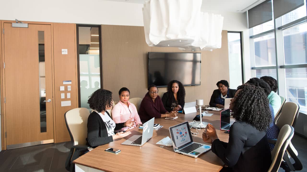 Pessoas com traje social sentadas numa sala de reunião - instituto ling