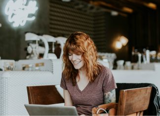 moça olhando notebook num café - cursos online gratuitos