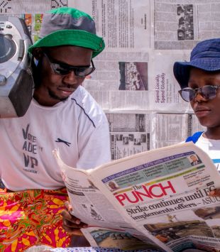 Duas pessoas, uma ouvindo rádio, a outra lendo jornal - mestrado em estudos midiáticos