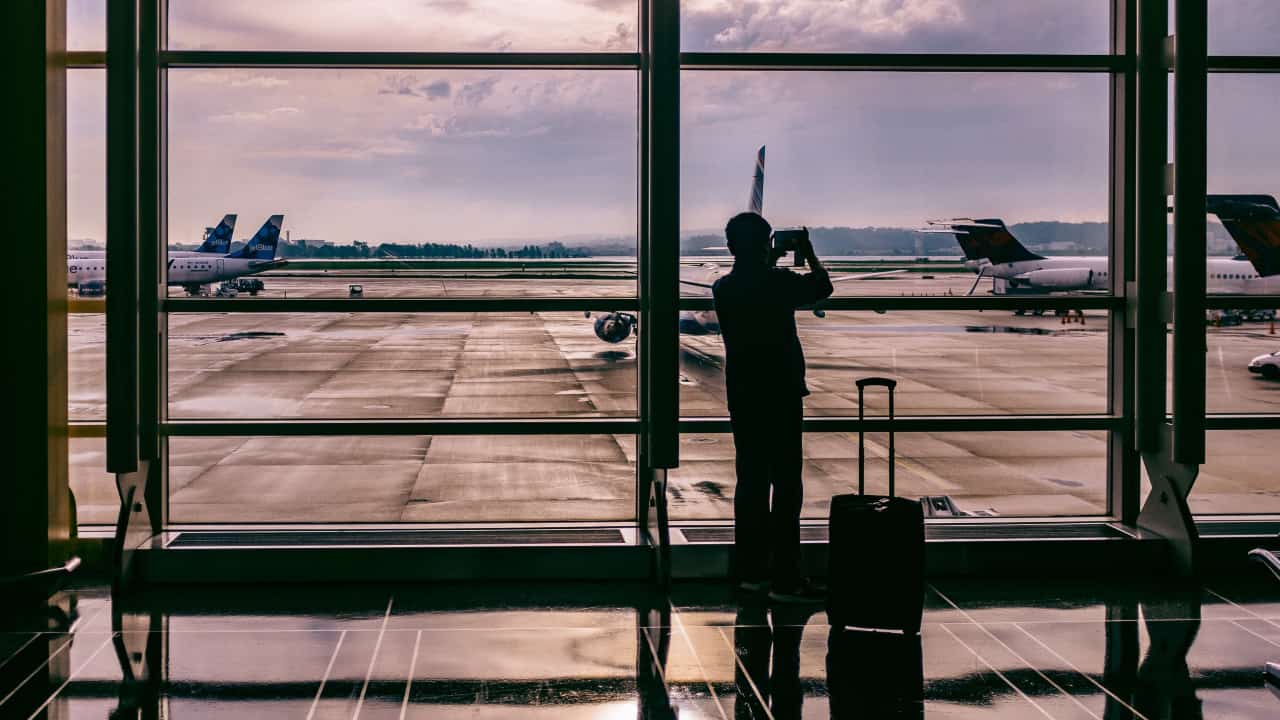 Pessoa no aeroporto fotografando a pista