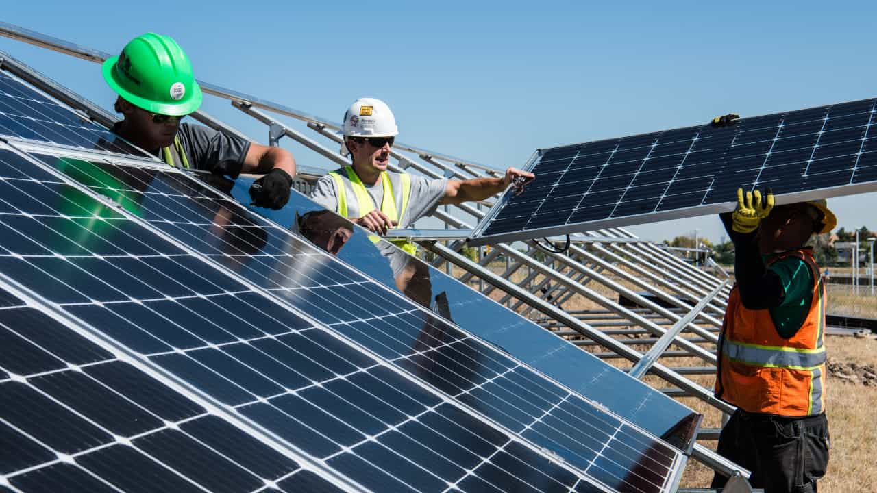 Engenheiros instalando painéis solares - mestrado em energia sustentável
