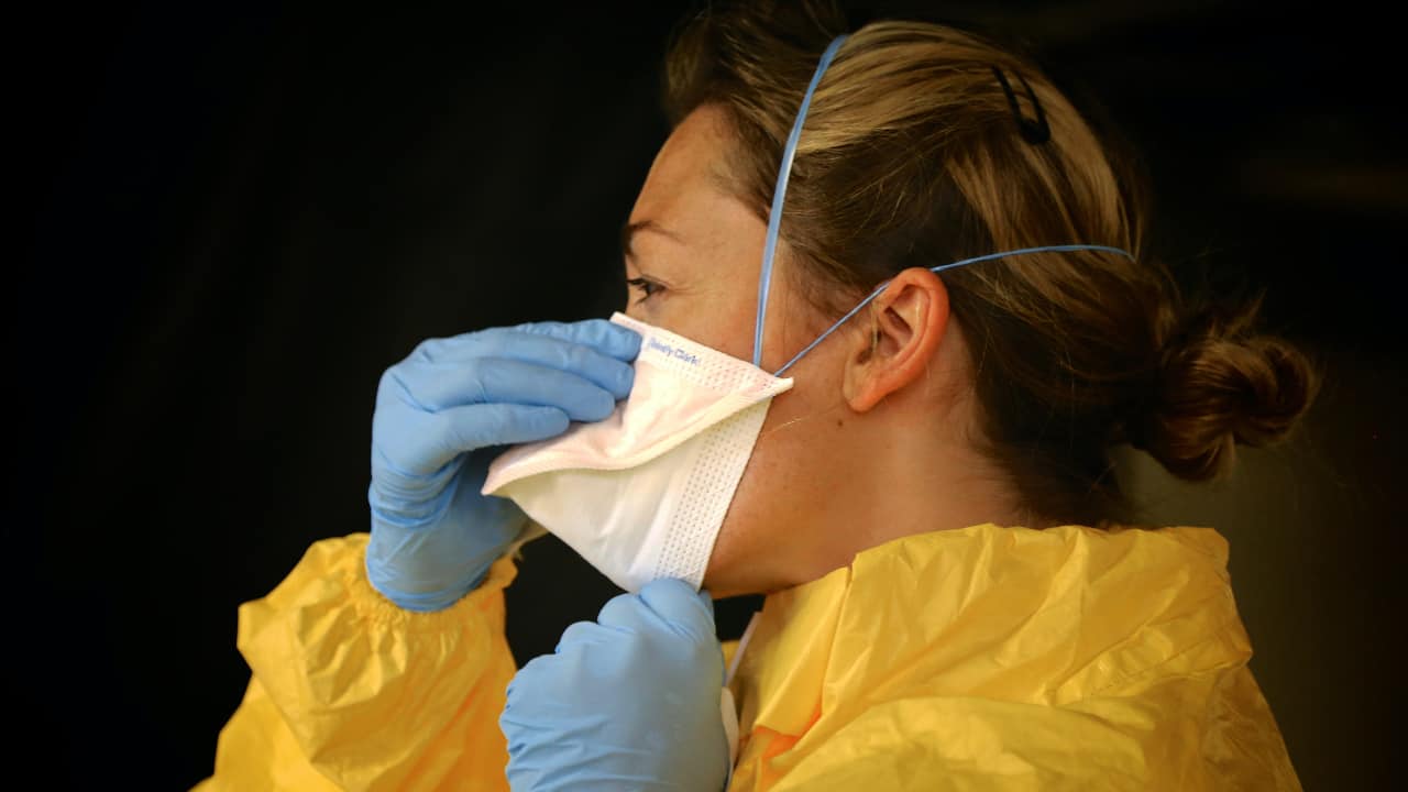 Pessoa de máscara e roupa protetiva - segunda onda da pandemia de COVID-19