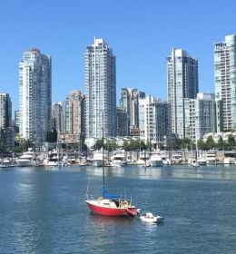 Um barco flutuando em frente a edifícios altos em Vancouver - MBA no Canadá
