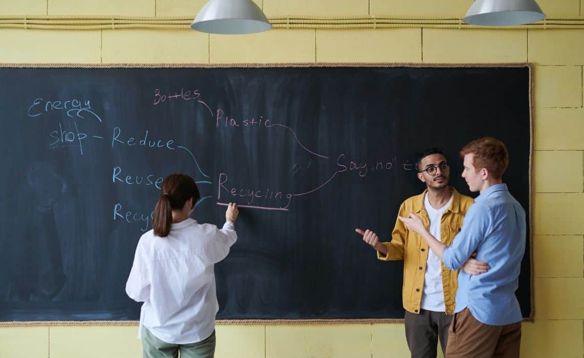 professores conversando em frente a uma lousa