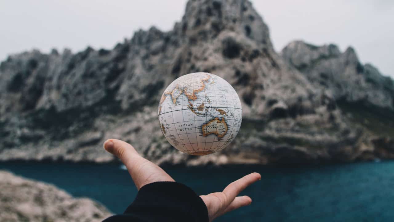 Pessoa com um globo terrestre flutuando sobre sua mão - global citizen year