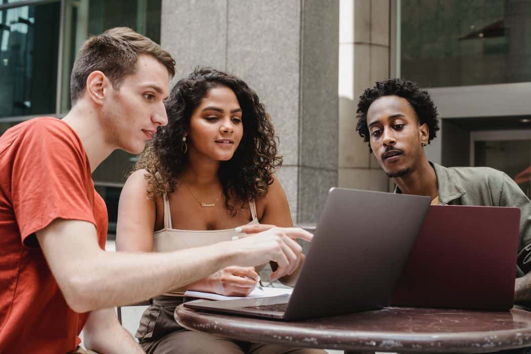 três jovens mexendo no computador