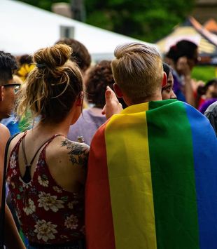 Pessoas de costas com bandeira LGBTQ