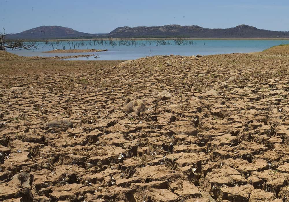 Rio brasileiro em período de seca e quase sem água envolto de terreno arenoso